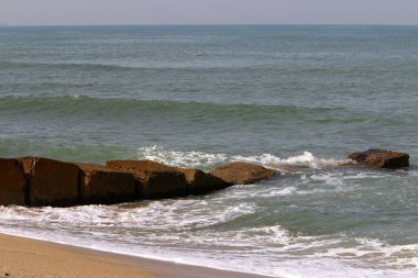 Akdeniz kıyılarındaki fırtına dalgalarından sahili korumak için dalgalı sulara devasa beton bloklar ve büyük taşlar konur. 
