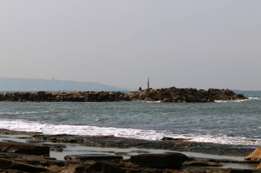 Akdeniz kıyılarındaki fırtına dalgalarından sahili korumak için dalgalı sulara devasa beton bloklar ve büyük taşlar konur. 