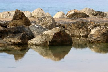 Akdeniz kıyılarındaki fırtına dalgalarından sahili korumak için dalgalı sulara devasa beton bloklar ve büyük taşlar konur. 