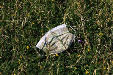 Corona virüsüne karşı korunmak için kullanılan tek kullanımlık tıbbi maske. Maske çöpe atıldı. WHO 'nun Coronavirus Kavramı: COVID-19. 