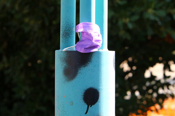 Disposable medical mask used to protect against corona virus close-up. The mask is thrown into the trash. WHO's Coronavirus Concept: COVID-19. 