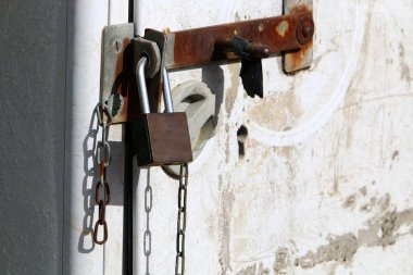Çitte asılı bir zincirin eski kilidi 