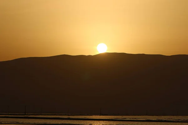 Dead Sea at dawn and the first ray of sun rising over the mountains in Jordan.