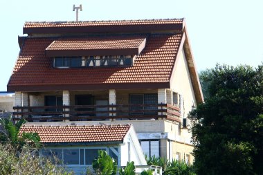 Evin çatısı kırmızı fayanslardan yapılmıştır. İsrail 'deki konut inşaatının mimari detayları. 