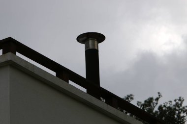 Mavi gökyüzüne karşı şömine kutusundaki hava akımını arttırmak için yüksek baca 