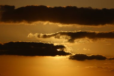 Güneş ufukta gökyüzünün alevli kırmızı ışığına karşı batar. 