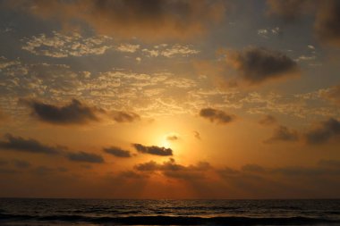 Güneş ufukta gökyüzünün alevli kırmızı ışığına karşı batar. 