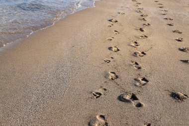 İsrail 'in kuzeyindeki Akdeniz kıyılarındaki kumlarda ayak izleri. İsrail 'de sıcak yaz. 