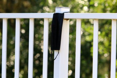 Corona virüsüne karşı korunmak için kullanılmış ve kirli bir tıbbi maske şehir parkında çöp gibi duruyor.. 