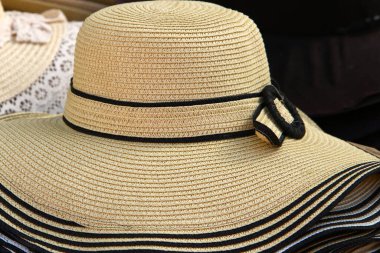 Bir dükkan vitrininde büyük bir hasır şapka var. 