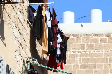 Yıkanmış giysiler apartmanın penceresinin dışındaki çamaşır ipinde kurumuş. İsrail 'de giysileri kurutmanın geleneksel yolu 