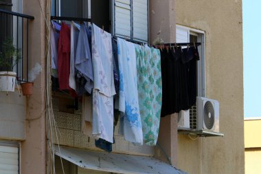 Yıkanmış giysiler apartmanın penceresinin dışındaki çamaşır ipinde kurumuş. İsrail 'de giysileri kurutmanın geleneksel yolu 