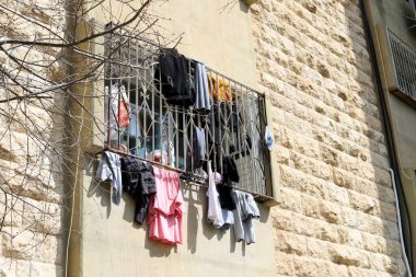 Yıkanmış giysiler apartmanın penceresinin dışındaki çamaşır ipinde kurumuş. İsrail 'de giysileri kurutmanın geleneksel yolu 