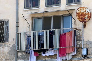 Yıkanmış giysiler apartmanın penceresinin dışındaki çamaşır ipinde kurumuş. İsrail 'de giysileri kurutmanın geleneksel yolu 