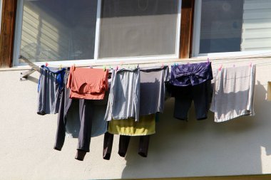Yıkanmış giysiler apartmanın penceresinin dışındaki çamaşır ipinde kurumuş. İsrail 'de giysileri kurutmanın geleneksel yolu 