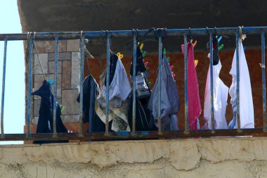Yıkanmış giysiler apartmanın penceresinin dışındaki çamaşır ipinde kurumuş. İsrail 'de giysileri kurutmanın geleneksel yolu 