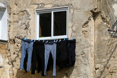 Yıkanmış giysiler apartmanın penceresinin dışındaki çamaşır ipinde kurumuş. İsrail 'de giysileri kurutmanın geleneksel yolu 