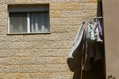 Yıkanmış giysiler apartmanın penceresinin dışındaki çamaşır ipinde kurumuş. İsrail 'de giysileri kurutmanın geleneksel yolu 