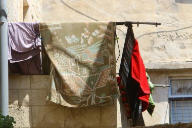 Yıkanmış giysiler apartmanın penceresinin dışındaki çamaşır ipinde kurumuş. İsrail 'de giysileri kurutmanın geleneksel yolu 