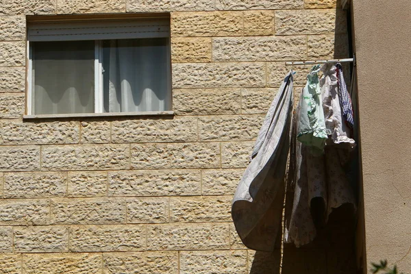 Yıkanmış giysiler apartmanın penceresinin dışındaki çamaşır ipinde kurumuş. İsrail 'de giysileri kurutmanın geleneksel yolu 