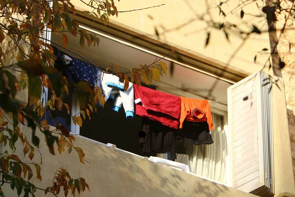 The washed clothes are dried on a clothesline outside the apartment window. The traditional way of drying clothes in Israel