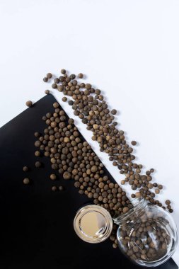 Beyaz masada siyah biberler, düz uzanmış.