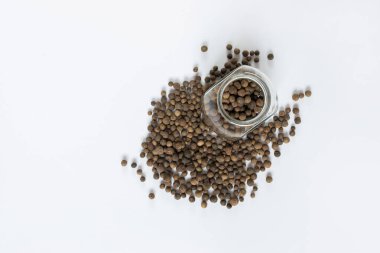 Beyaz masada siyah biberler, düz uzanmış.