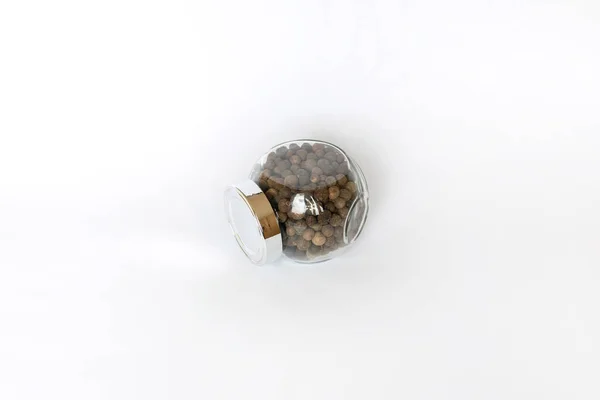 Beyaz masada siyah biberler, düz uzanmış.