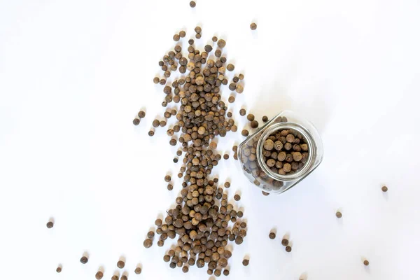 Beyaz masada siyah biberler, düz uzanmış.