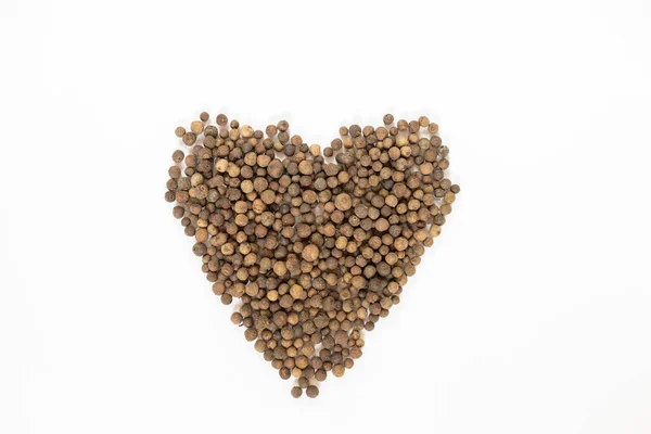 Beyaz masada siyah biberler, düz uzanmış.