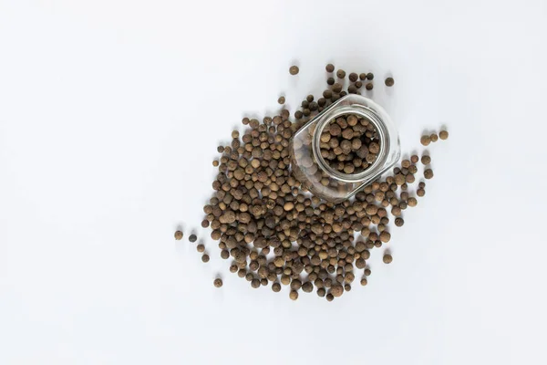 Beyaz masada siyah biberler, düz uzanmış.