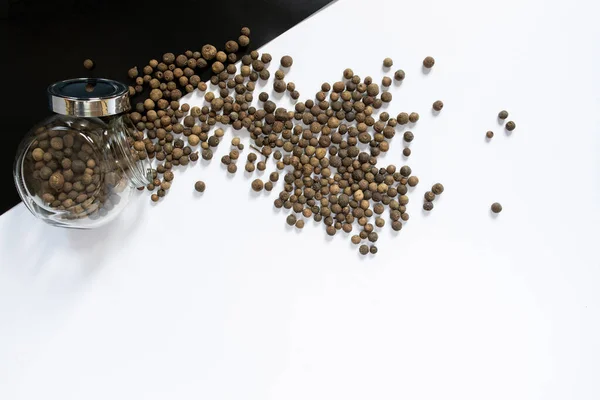 Beyaz masada siyah biberler, düz uzanmış.