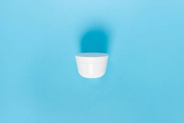 Sıvı, krem, jöle ve losyon için kavanoz. Mavi arka planda osmetik kavanoz. SPA kozmetik ürünleri markalaştırma modeli. Düz yatış minimalist tarzı.