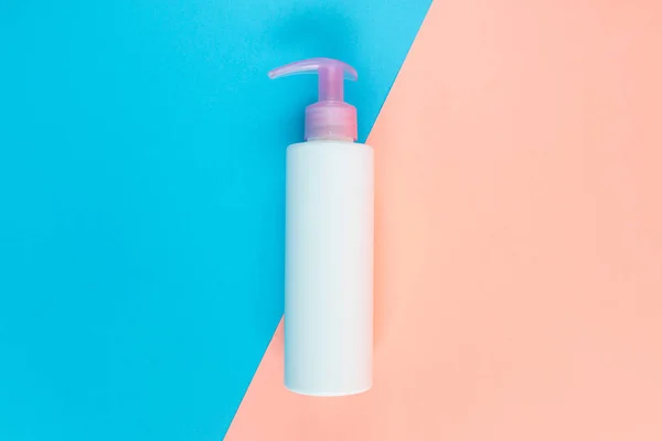 Sıvı, krem, jöle ve losyon için şişe. Mavi ve gül arkaplanlı osmetik şişe. SPA kozmetik ürünleri markalaştırma modeli. Düz yatış minimalist tarzı.