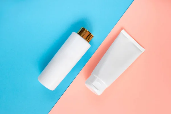 Sıvı, krem, jöle ve losyon için makyaj seti. Mavi ve gül arkaplanlı osmetik şişe. SPA kozmetik ürünleri markalaştırma modeli. Düz yatış minimalist tarzı.