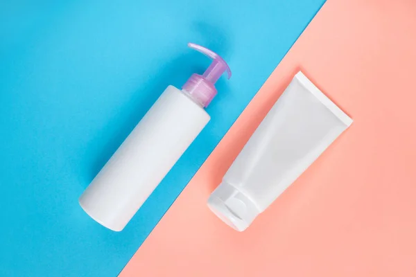 Sıvı, krem, jöle ve losyon için makyaj seti. Mavi ve gül arkaplanlı osmetik şişe. SPA kozmetik ürünleri markalaştırma modeli. Düz yatış minimalist tarzı.