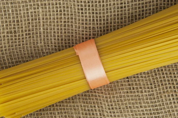 Keten kumaş üzerine bir kurdele ile bağlanmış spagetti