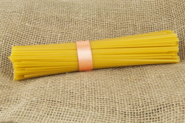 Keten kumaş üzerine bir kurdele ile bağlanmış spagetti