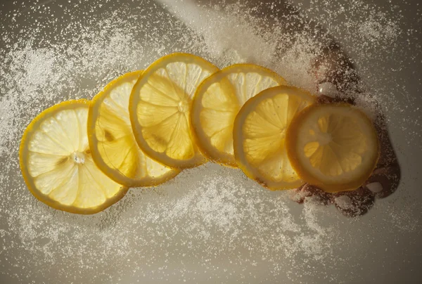 Zitronenscheiben mit Zucker auf einem Glastisch — Stockfoto