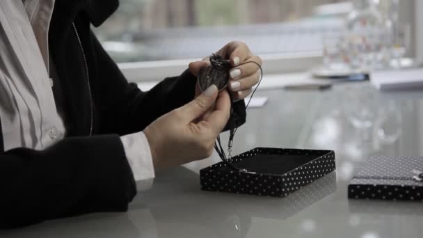 Woman examines a piece of jewelry — Stock Video