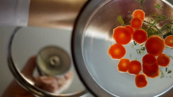 用胡萝卜和香草在玻璃锅里的汤。特写 — 图库视频影像