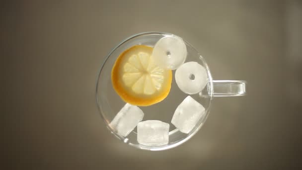 Bevanda estiva con limone e ghiaccio su una superficie di vetro. flatlay — Video Stock