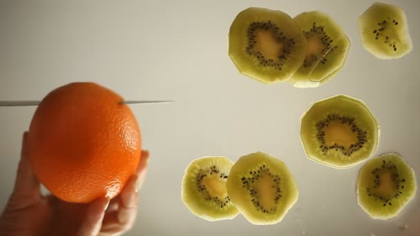 Оранжевый и киви, нарезанные на стеклянной поверхности — стоковое видео