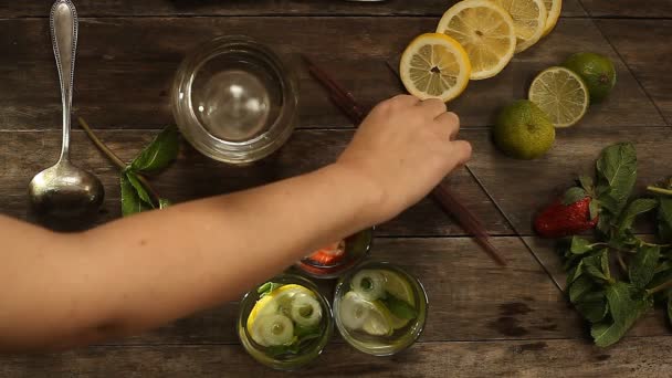 Voorbereiding van drie zomer cocktails op een houten tafel. van bovenaf bekijken — Stockvideo