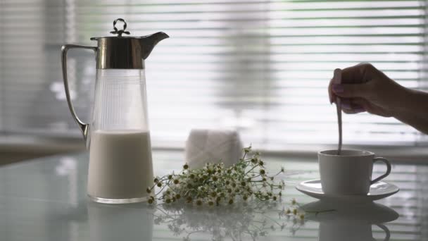 Букет маргаритки и чашку кофе на столе — стоковое видео