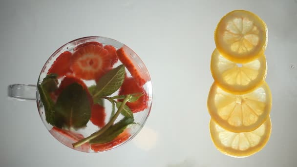 Fragola, limone, menta e ghiaccio su una superficie di vetro. flatlay — Video Stock