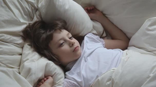 Симпатична маленька дівчинка спить у ліжку — стокове відео