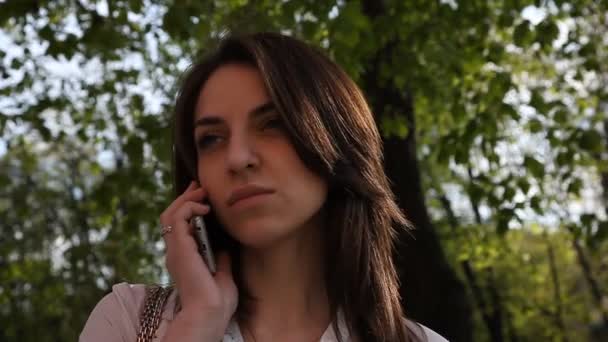 Menina ligando no telefone em um parque da cidade — Vídeo de Stock