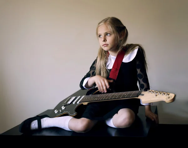 Pensativo linda niña con una guitarra sentado en el suelo — Foto de Stock