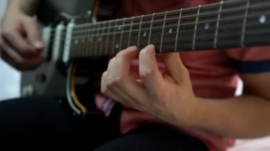 Genç adam gitar çalmaya. yakın çekim